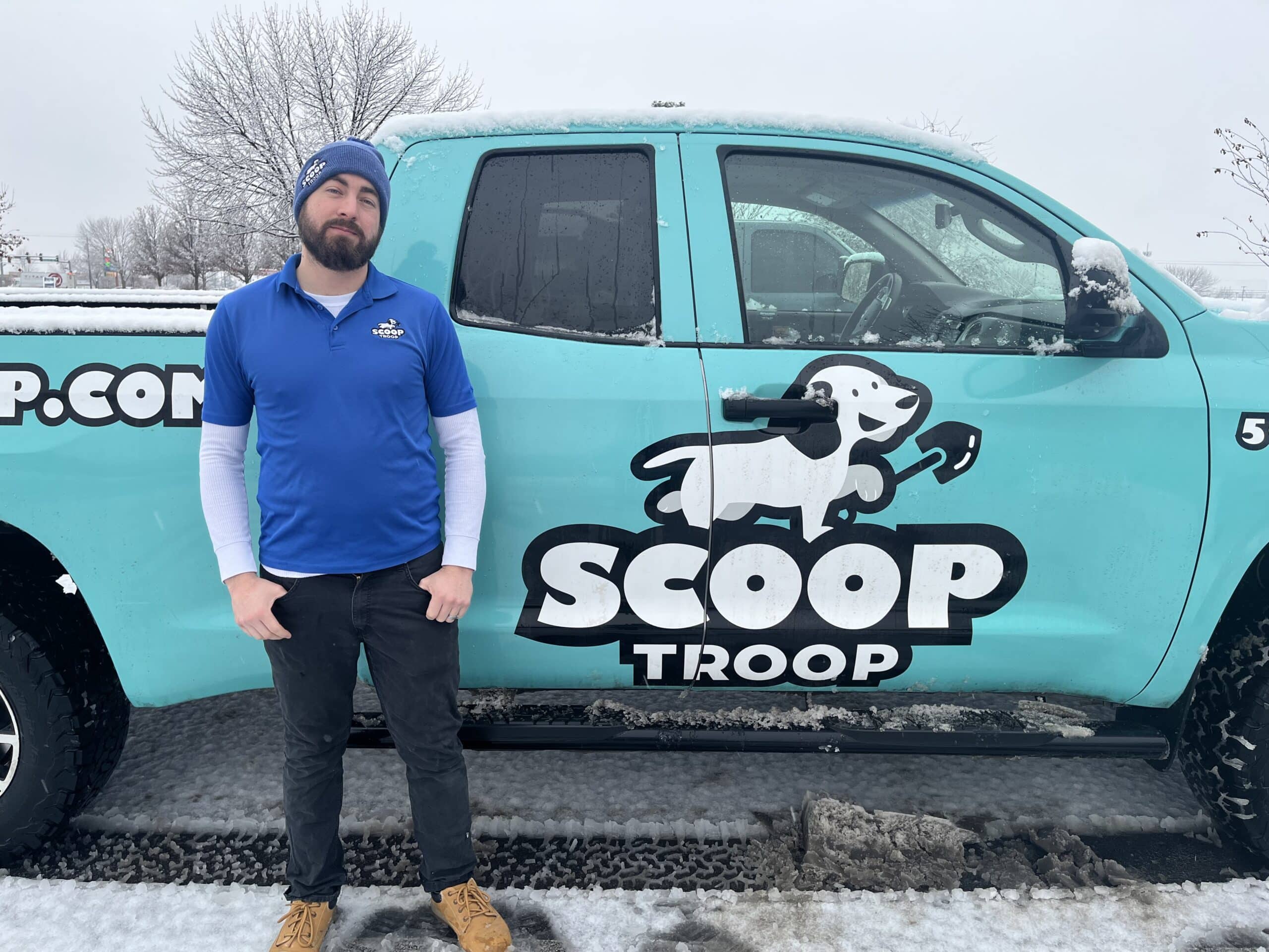 Scoop Troop employee in North Idaho standing in front of a company truck.